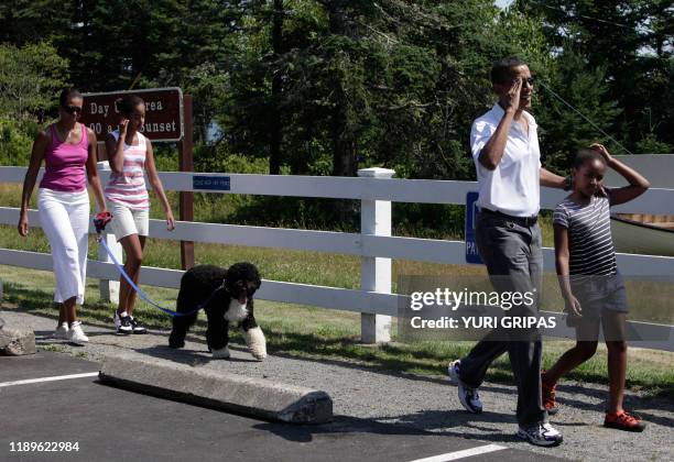 President Barack Obama with First Lady Michelle Obama and their daughters Malia and Sasha walk with their dog Bo as they visit the Bass Harbor Head...