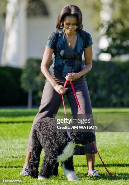 First Lady Michelle Obama stands with the family dog Bo as she hosts a "Let's Move!" event on the South Lawn of the White House in Washington, DC,...