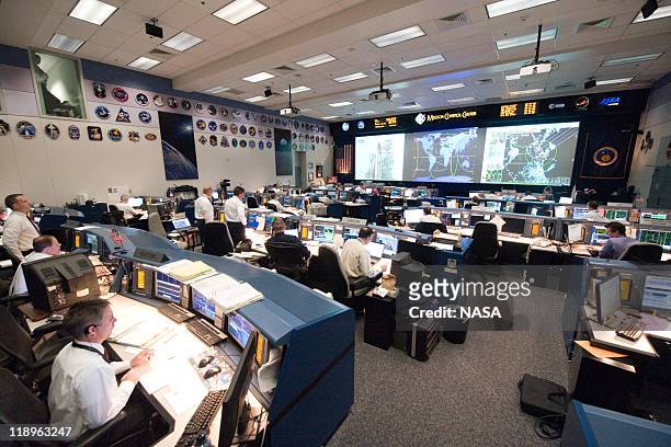 In this handout image provided by the National Aeronautics and Space Administration , Flight controllers on sit behind their consoles in shuttle...