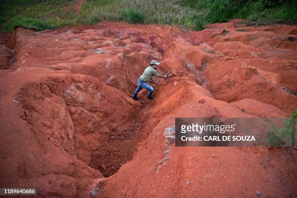 Paleontologist Jose Darival Ferreira digs at an excavation site in Agudo, Brazil, on December 3, 2019. - In 2014, the paleontology team at CAPPA...