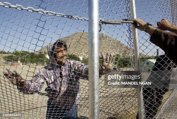 Workers at the Kabul Polytechnic Institute erect close perimeter fencing, 16 May 2002 around a field which will be the venue for a large tent housing...