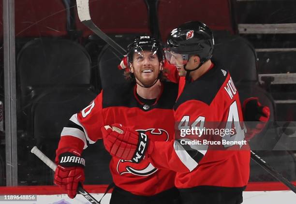 Blake Coleman of the New Jersey Devils celebrates his empty net goal at 19:48 of the third period against the Detroit Red Wings and is joined by...