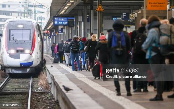 December 2019, Baden-Wuerttemberg, Stuttgart: At the beginning of the Christmas holiday season, passengers wait at Stuttgart Central Station for a...