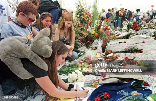 Amber Johnson writes a note for the Columbine High School shooting victims with friends Jessi Wilson Kira Osado and Krystal Osado 26 April 1999 at...