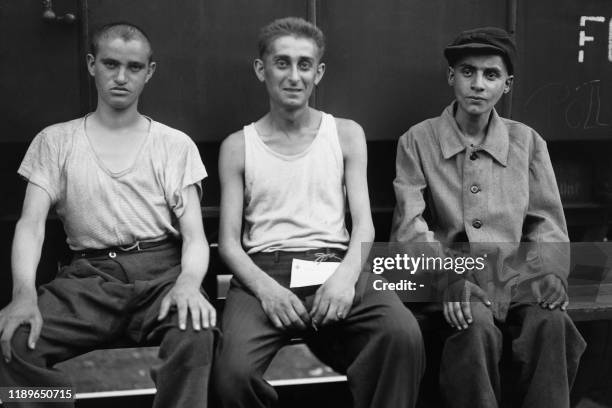 Teenagers repatriated from the German concentration camp of Buchenwald pose in front of the train that brought them back from Germany upon their...