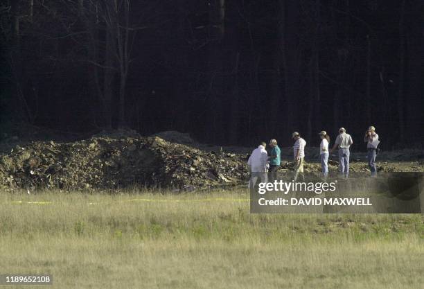 Officials examine the crater 11 September 2001 at the crash site of United Airlines Flight 93 in Shanksville, Pennsylvania. The plane from Newark,...