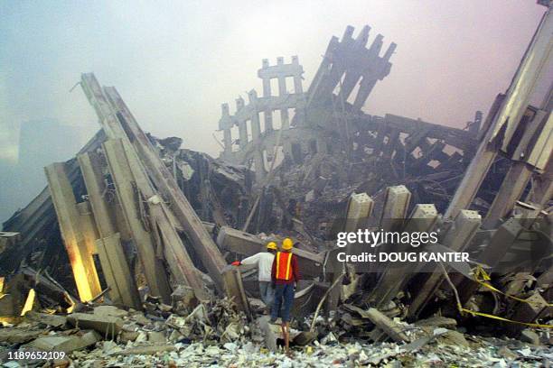 Rescue workers survey damage to the World Trade Center 11 September, 2001 in New York. Two planes controlled by hijackers crashed into the twin...