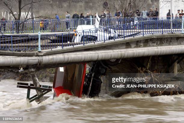 Un semi-remorque est suspendu par un essieu, le 03 décembre 2003 à Givors, au reste du tablier d'un pont qui s'est effondré en raison des intempéries...