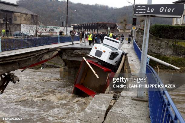 Un semi-remorque est suspendu par un essieu, le 03 décembre 2003 à Givors, au reste du tablier d'un pont qui s'est effondré en raison des intempéries...