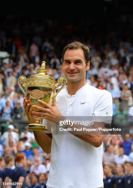 Roger Federer of Switzerland poses with the Wimbledon Championship trophy as he celebrates winning the gentlemen's singles final match against Marin...