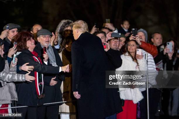 President Donald Trump shakes hands with guests as he leaves the White House before departing for Joint Base Andrews on December 20, 2019 in...