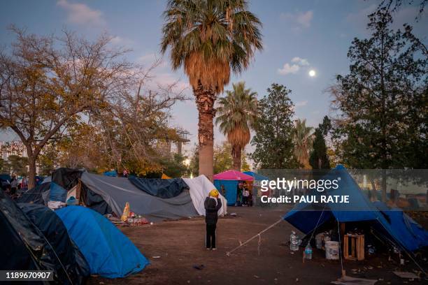 Boy plays ball on December 10 inside an encampment of asylum seekers from all around Mexico in Ciudad Juarez, Mexico. - In the mud and biting cold of...