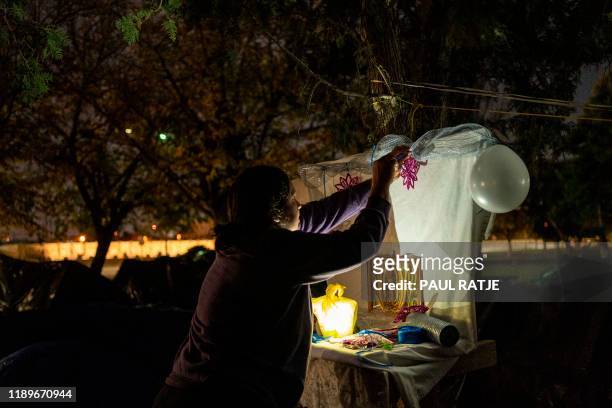 Woman from Michoacan State decorates an altar set up for Día de Nuestra Señora de Guadalupe in Ciudad Juarez, Mexico, on December 11, 2019. - In the...