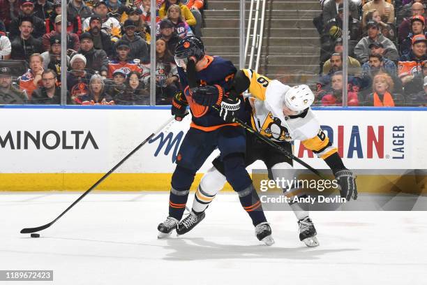 Leon Draisaitl of the Edmonton Oilers keeps the puck away from John Marino of the Pittsburgh Penguins on December 20 at Rogers Place in Edmonton,...