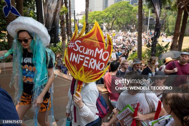 Demonstrators hold up placards during a climate protest rally in Sydney on December 21, 2019. - Hundreds of protesters gathered at First Fleet Park...