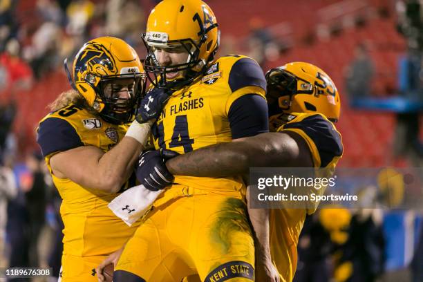 Kent State Golden Flashes quarterback Dustin Crum runs through the line of scrimmage and scores a touchdown and celebrates with his teammates during...