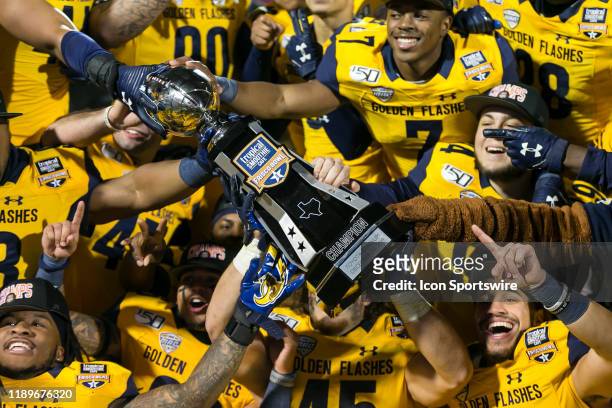 The Kent State Golden Flashes celebrate winning the Tropical Smoothie Cafe Frisco Bowl trophy after the game between the Utah State Aggies and the...
