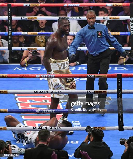 Referee Kenny Bayless directs Deontay Wilder to a neutral corner after he knocked out Luis Ortiz in the seventh round of their WBC heavyweight title...
