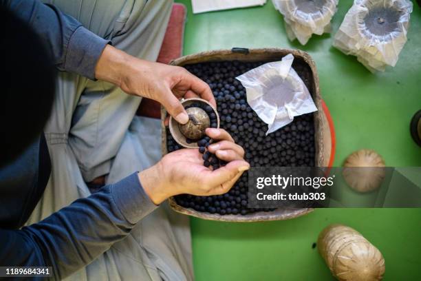 man assembling fireworks by hand in preparation for a celebratory event or festival - gunpowder stock pictures, royalty-free photos & images