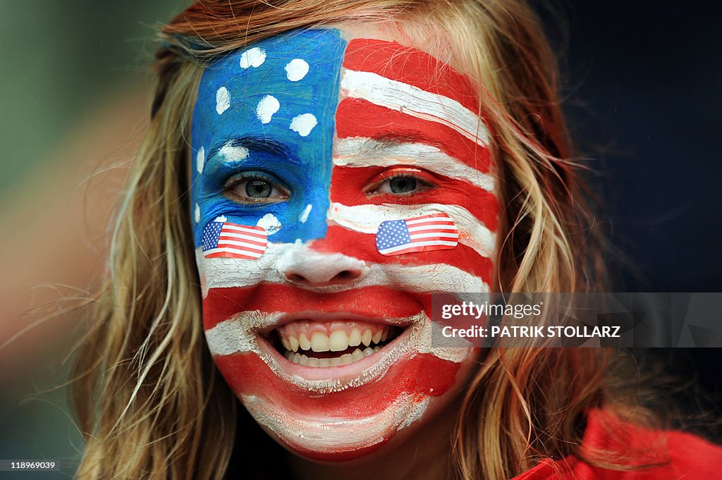 A USA fan with her face painted cheers p