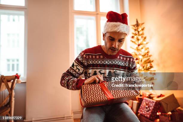 sad man celebrate the christmas alone at home - unwrapped stock pictures, royalty-free photos & images