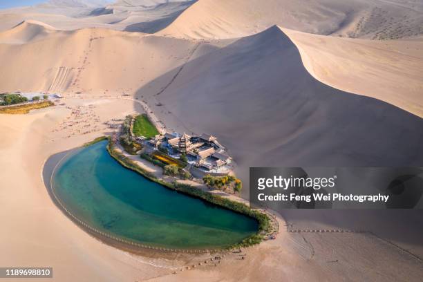 crescent lake with buddhist temple in kumtag desert, dunhuang, gansu china - desert oasis stock pictures, royalty-free photos & images