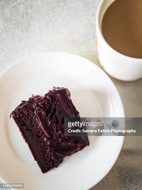 high angle view of chocolate cake slice in plate and coffee served on table - chocolate cake bildbanksfoton och bilder