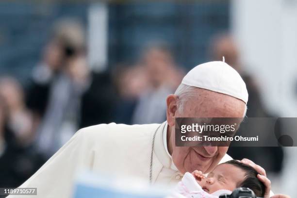 Pope Francis looks at a baby as he arrives for a Holy Mass at Nagasaki Baseball Stadium on November 24, 2019 in Nagasaki, Japan. Pope Francis is...