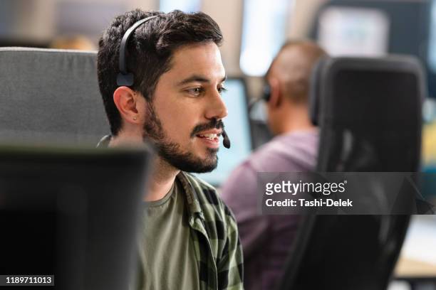 man talking to a customer over a headset - hotline stock pictures, royalty-free photos & images