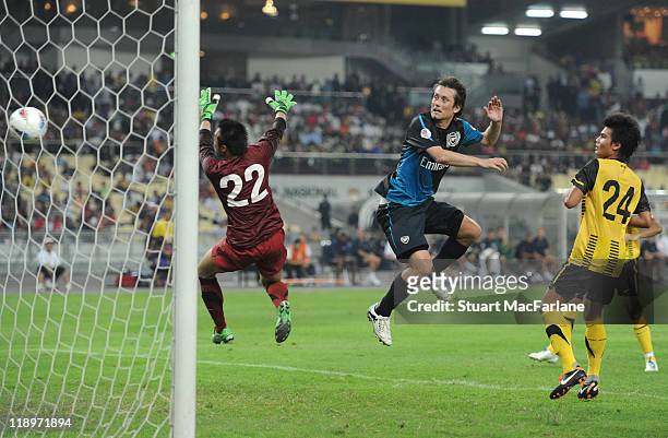 Tomas Rosicky of Arsenal heads past Mohd Nasril of Malaysia to score the 4th goal during the pre-season Asian Tour friendly match between Malaysia...