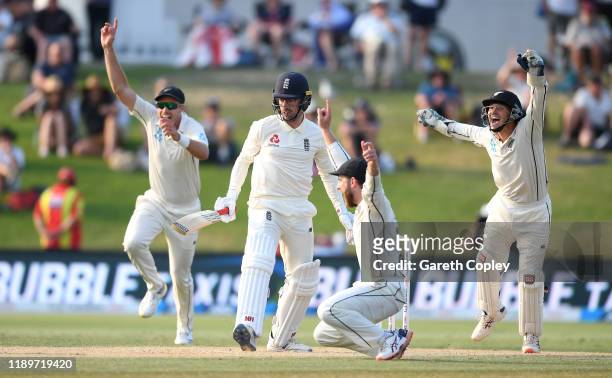 Tim Southee, Kane Williamson and BJ Watling of New Zealand successfully appeal for the wicket of Jack Leach of England during day four of the first...