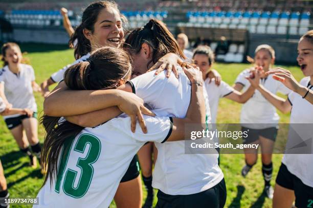 feiern sie den sieg nach dem fußballspiel! - frauenfußball stock-fotos und bilder