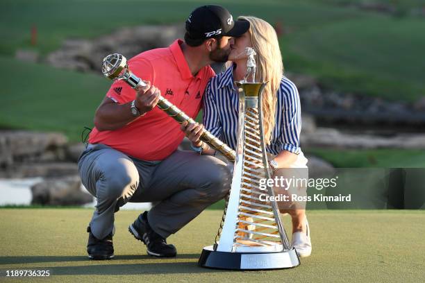 Jon Rahm of Spain poses with his fiance Kelley Cahill and the DP World Tour Championship trophy and the Race to Dubai trophy following his victory...