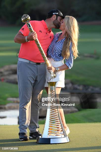 Jon Rahm of Spain poses with his fiance Kelley Cahill and the DP World Tour Championship trophy and the Race to Dubai trophy following his victory...