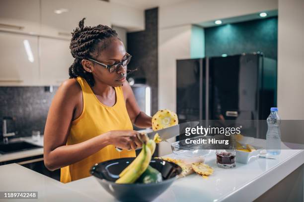 woman making fruit salad - pineapple cut stock pictures, royalty-free photos & images