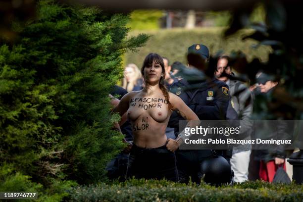 Activist with body painting reading 'To fascism neither honor nor glory' is retained by police after she protested during a rally commemorating the...