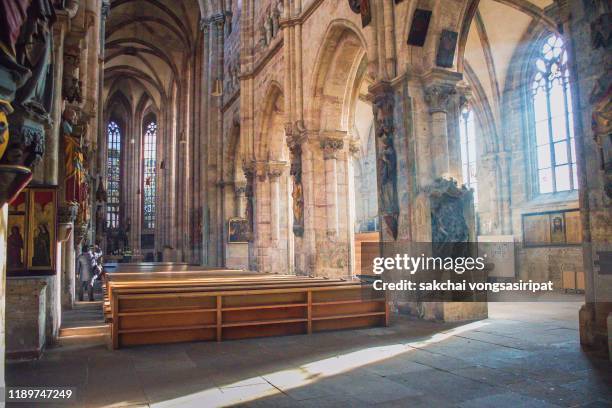 inside st. sebald church(sebalduskirche) built from the 13th to 15th cuntury, and removated after sustaining heavy damaage from bombings of world war ii. in the center of the church is the grave of the city saint, depicting scenes of his life, nuremberg, - church inside stock-fotos und bilder