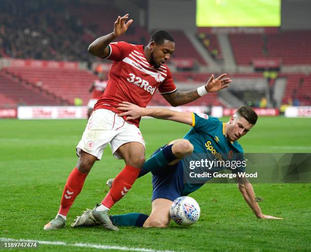 Britt Assombalonga of Middlesbrough battles for possession with Reece Burke of Hull City during the Sky Bet Championship match between Middlesbrough...
