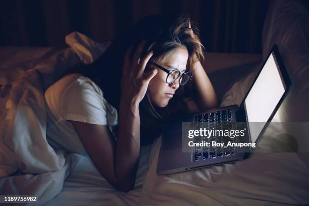 portrait of young woman worried and serious about her jobs did not finish yet in the night time. - asian sleeping stock pictures, royalty-free photos & images