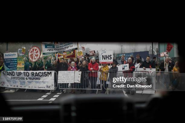 Protesters gather outside Telford International Centre as Prime minister Boris Johnson arrives on board a bus for the launch of the Conservative...