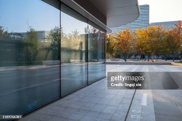 glass facades and squares of buildings in a business district in hangzhou, china - reflection photos et images de collection