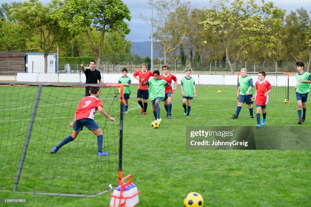 Young Cuban male footballer dribbling ball toward goal
