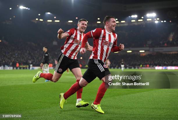 John Fleck of Sheffield United celebrates after scoring his sides first goal with teammate John Lundstram during the Premier League match between...