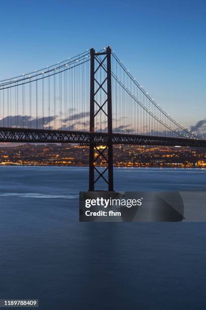 lisbon - ponte 25 de abril twilight (bridge of april 25) - portugal - 25 de abril bridge stockfoto's en -beelden