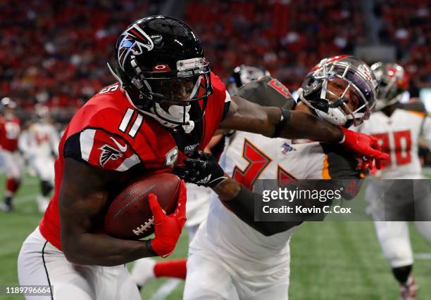 Julio Jones of the Atlanta Falcons stiff arms Carlton Davis of the Tampa Bay Buccaneers after a reception in the first half at Mercedes-Benz Stadium...