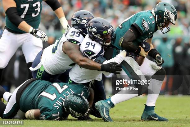 Quinton Jefferson and Ezekiel Ansah of the Seattle Seahawks sack quarterback Carson Wentz of the Philadelphia Eagles in the first half at Lincoln...