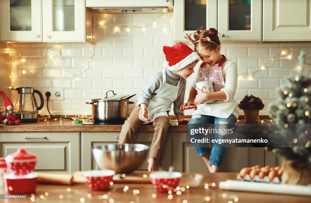 Glückliche Kinder Junge und Mädchen backen Weihnachtsplätzchen