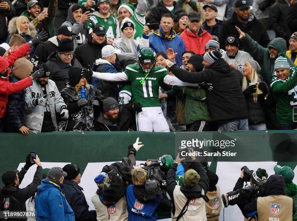 Wide receiver Robby Anderson of the New York Jets jumps into the stands after scoring a touchdown during the second half of the game against the...