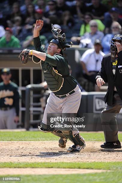 Catcher Landon Powell of the Oakland Athletics tosses his mask while attempting to field a bunt during the game against the Chicago White Sox on June...