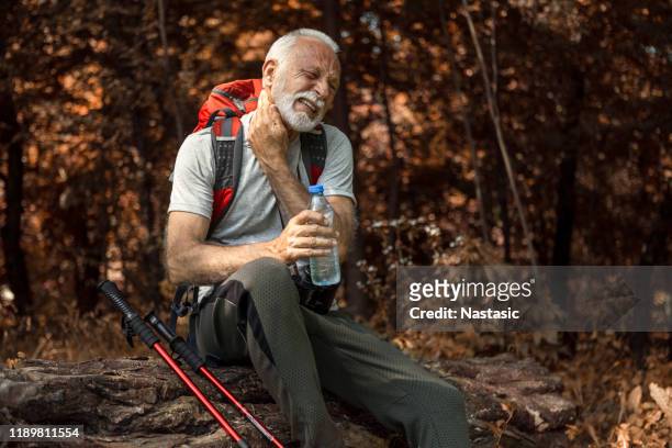 caminhada sapateada do homem sênior que toma uma água bebendo da ruptura que defende do mosquito - insect bites images - fotografias e filmes do acervo
